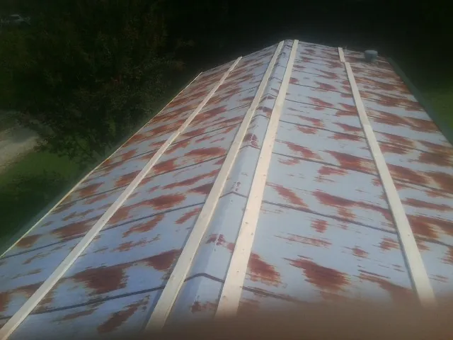 Rusted metal roof panels with new wood purlins before replacement — Storm Damage Roof Repair in Loami by Roofing Brothers